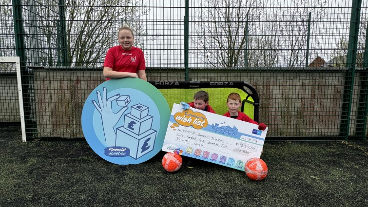 This image shows some of the young people of Fernhill Soccer School posing with props following a Community Wish List donation