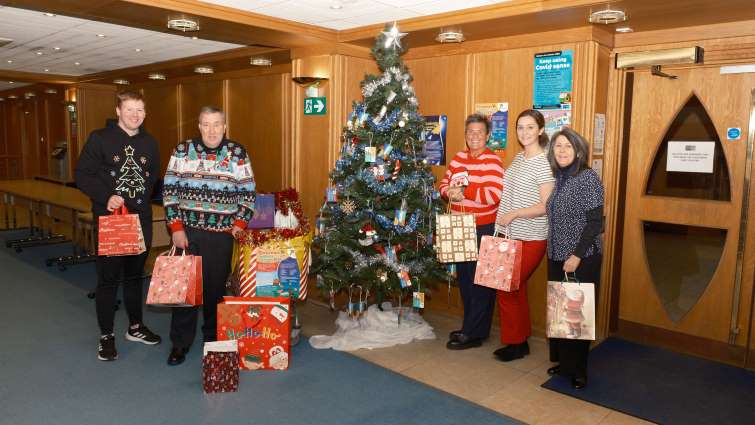 This image shows SLC staff at a Christmas tree following a period of donating gifts