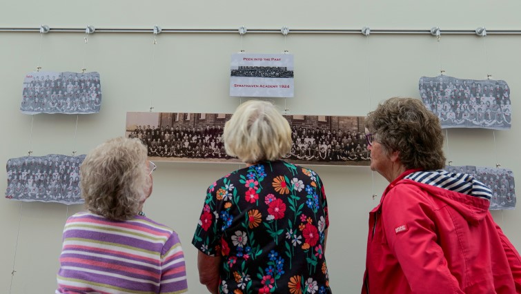local residents looking at the digitally enhanced photo from when Strathaven Academy first opened 100 years ago