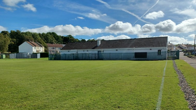 This image shows the pitch at Eddlewood FA in the foreground with the clubhouse in the background