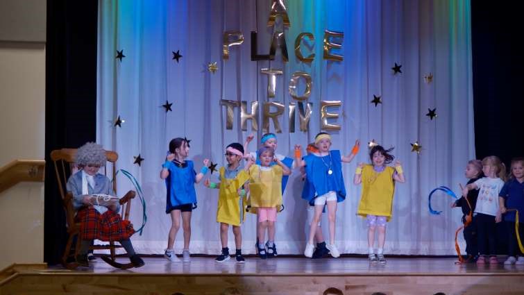 This image shows pupils performing on stage at the official opening of Jackton Primary School