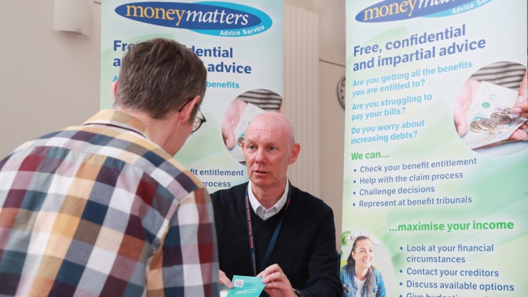 This photo shows the back of the head of a male client talking to a money matters adviser