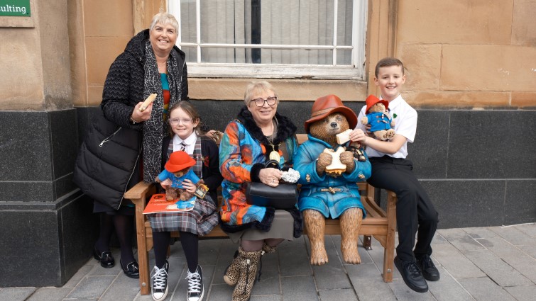 This image shows Provost Margaret Cooper and Councillor Catherine McClymont with two Lanark Primary School pupils at the unveiling of the Paddington Bear statue in Lanark