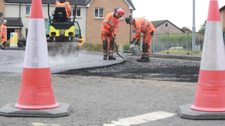 This image shows a road being resurfaced by council workers