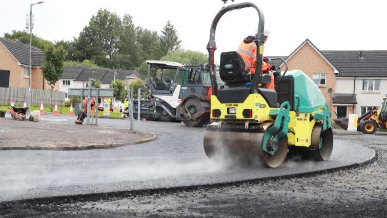 This images shows a council worker and vehicle resurfacing part of a roundabout