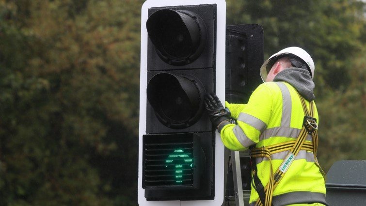 This image shows a roads worker installing lights on the A72