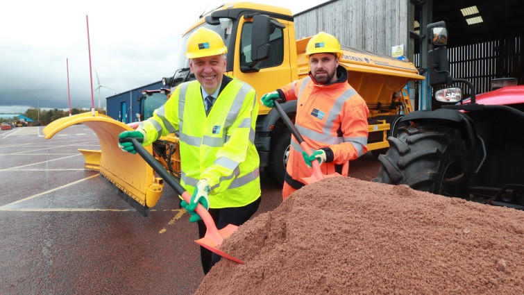 Councillor Robert Brown and one of the depot team are pictured with snow shovels next to a large mound of grit.