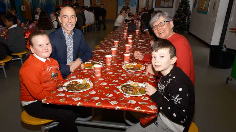 This image shows Councillor Maureen Devlin and Kevin Carr at Christmas lunch with pupils from Park View Primary School