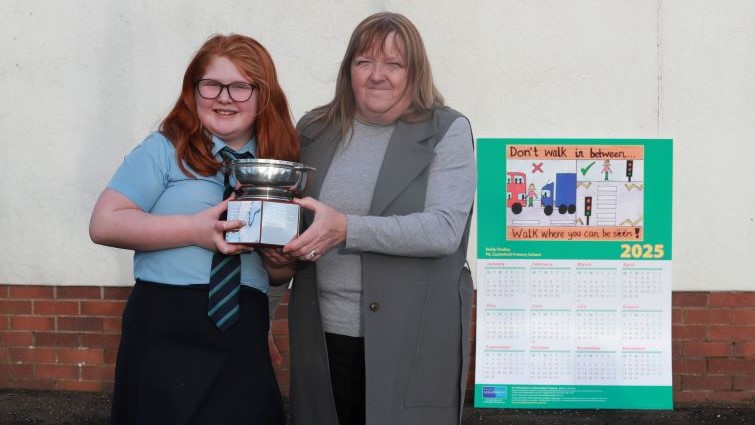 Councillor Margaret Cowie presents Emily Findlay, P6 at Castlefield PS, East Kilbride, with her trophy for winning the Road Safety Calendar Competition for 2024-25. 